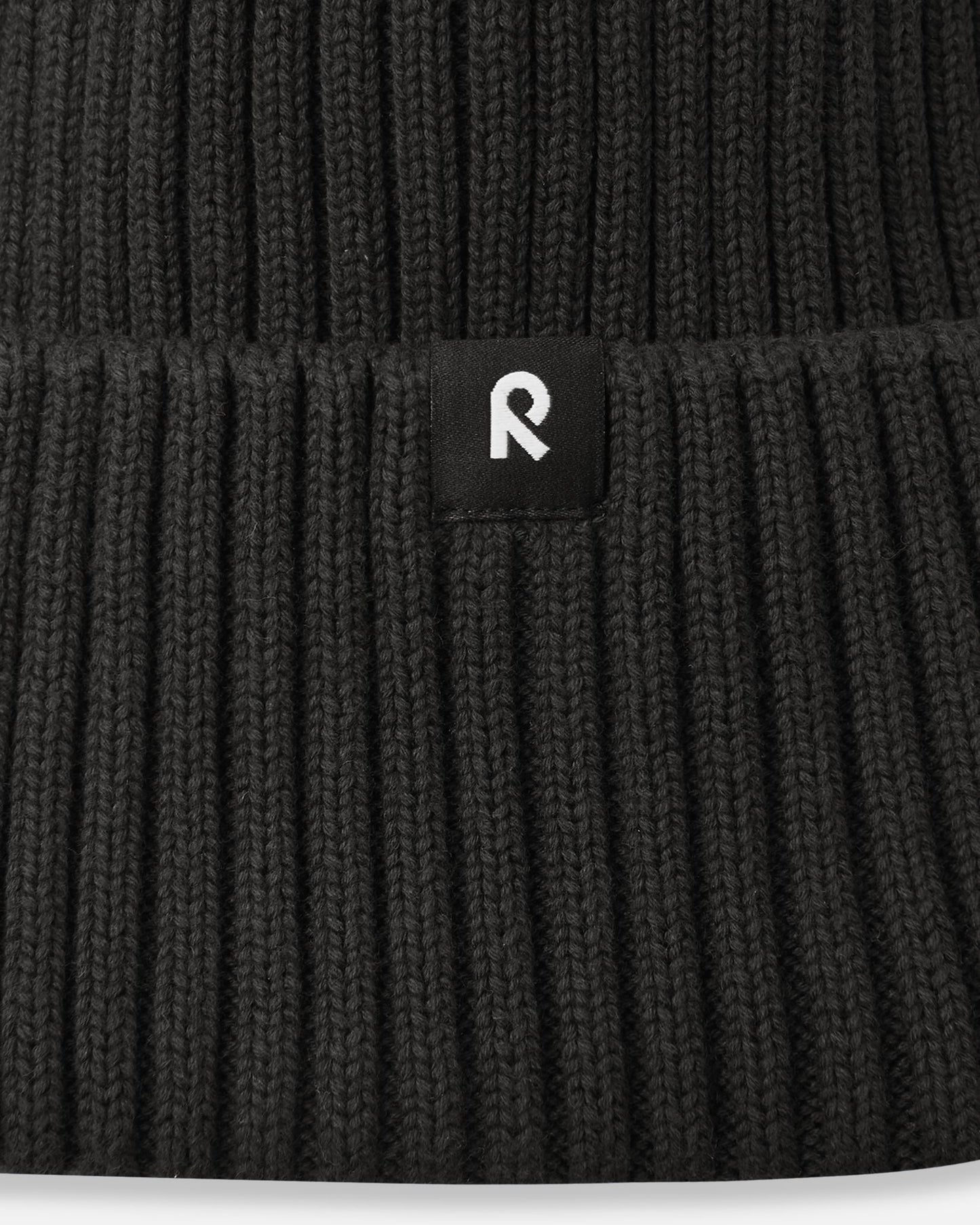 Close-up of the deep Black 100% organic cotton ribbed fabric on the Hattara beanie with a wide folded brim.