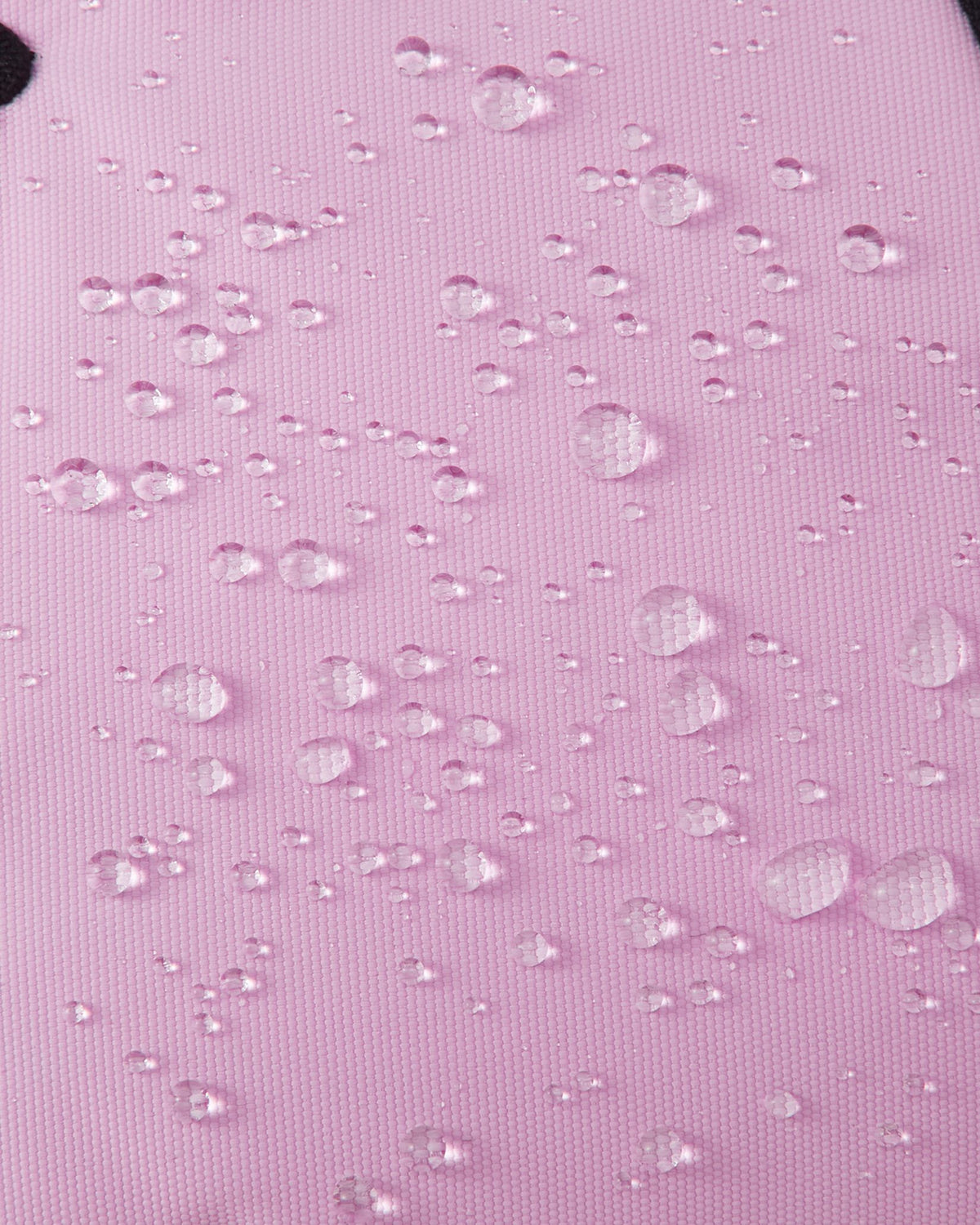 Macro texture shot of the light heather pink exterior fabric on Reima Hankas Reimatec kids ski gloves, with water droplets perfectly beading to showcase its highly waterproof finish.
