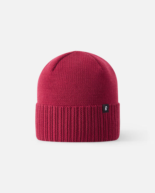 Straight-on view of the cranberry red Reima Kalotti kids merino wool beanie, showcasing its traditional Scandinavian winter design, unlined breathable upper crown, and thick heat-retaining ribbed cuff.