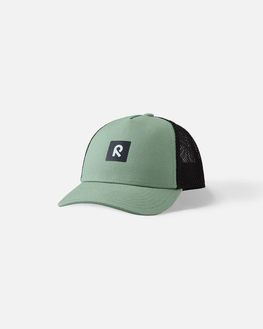 Front view of the Reima Liplatus kids' organic cotton cap in stone green, showcasing the durable pale green woven front panel, breathable black mesh back, and central Reima logo.