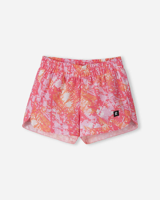 Front view of the Reima Nauru girls' UPF 50+ sunproof swim shorts, featuring a bright soft coral, pink, and orange abstract pattern, crafted from highly protective UV-blocking material.
