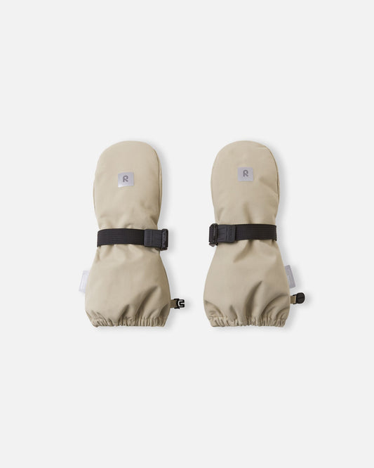 Top view of the earthy beige Reima Ote kids' winter mittens, featuring a reflective safety logo, a durable waterproof outer shell, and an adjustable black velcro wrist strap to keep out snow.