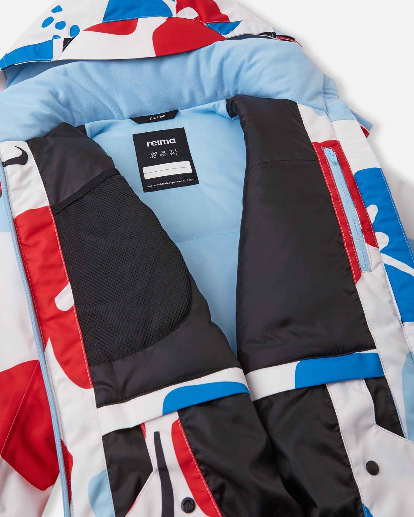 Inside view of the white Reima Posio kids' waterproof ski jacket, showing the smooth blue inner lining, internal mesh goggle pocket, and zippered chest pocket.