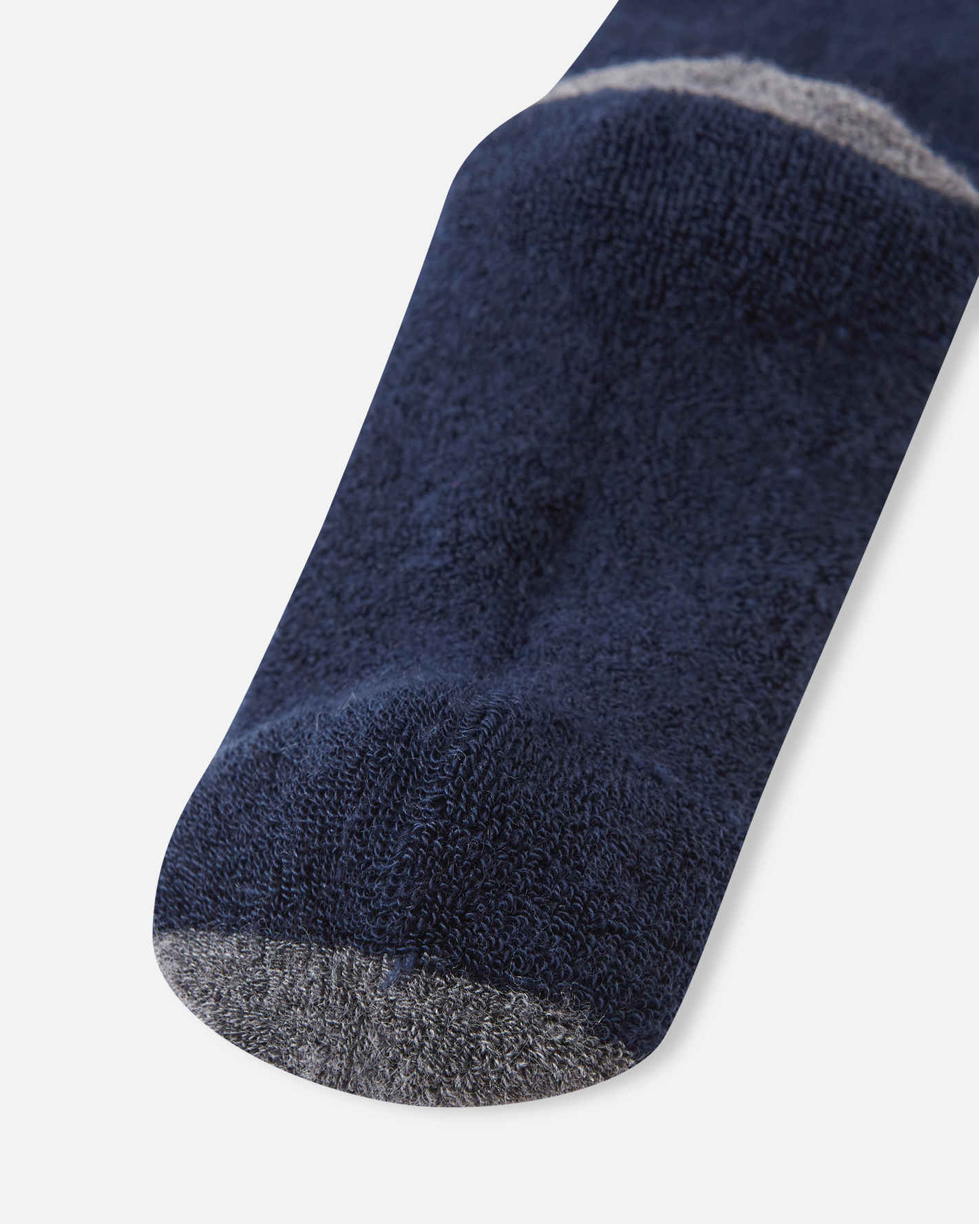 Detailed close-up of the footbed and toe area on the navy blue Reima Saapas kids' wool socks, highlighting the plush knit texture and the durable dark grey reinforced toe.