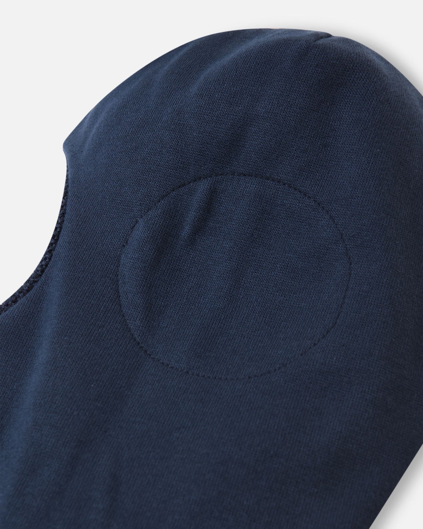 Close-up inside the navy Reima Starrie toddler balaclava, revealing the specially designed windproof ear protection inserts built into the fabric to prevent frostbite.