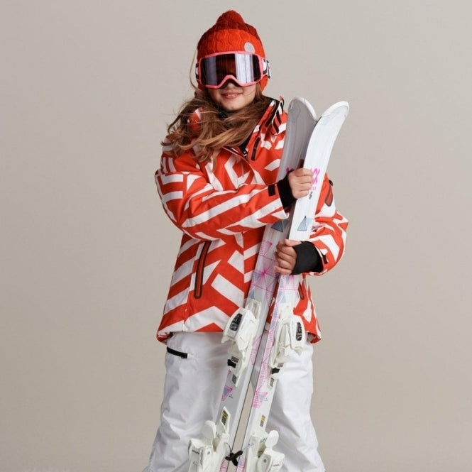Child bundled up for the slopes in essential Reima winter outerwear, featuring a highly visible red and white ski jacket, a warm red beanie, and snow goggles from our ski lesson checklist.