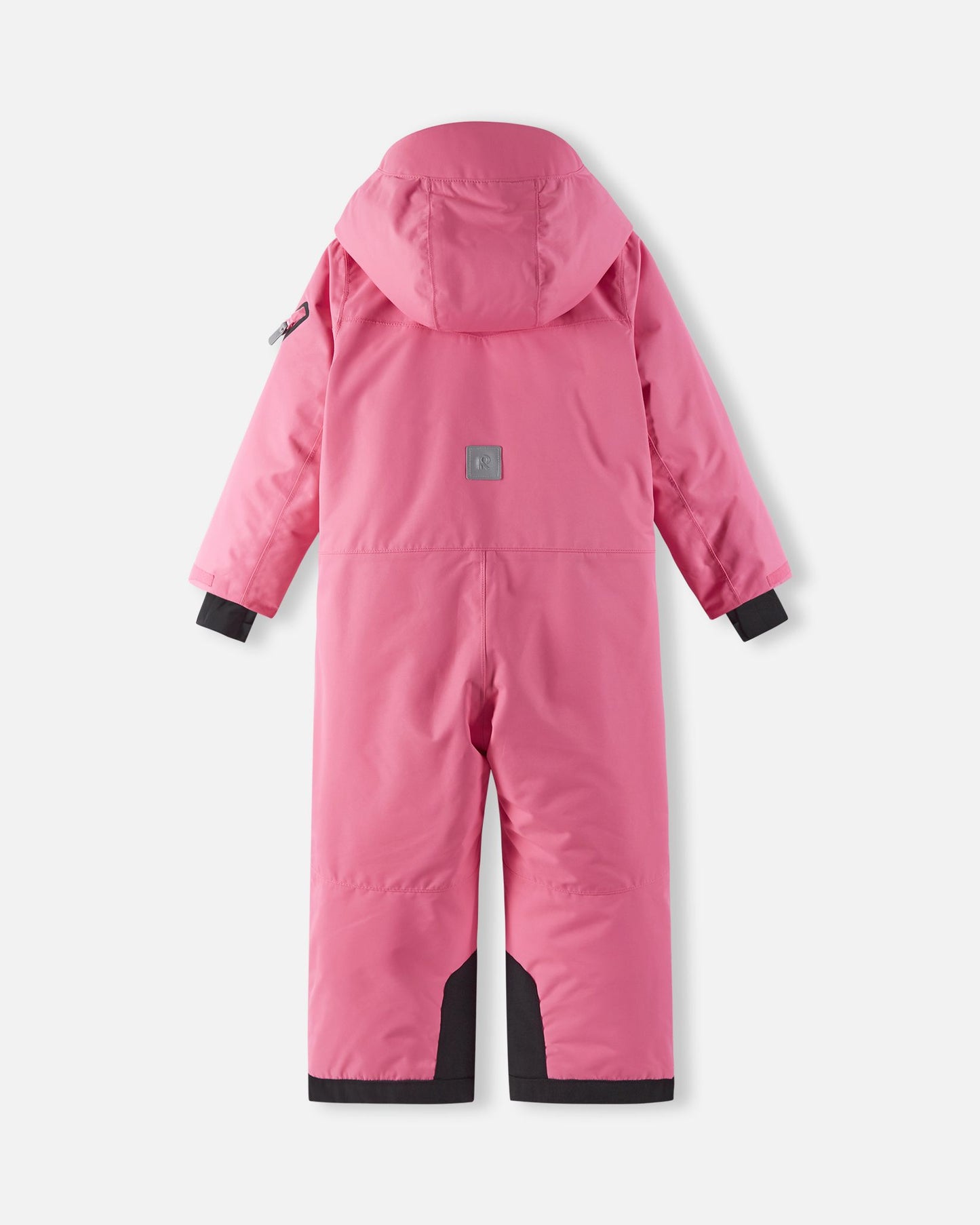 Back view of the Reima Reach girls' winter snowsuit in soft coral, highlighting the adjustable winter hood, a high-visibility reflective safety patch, and heavy-duty black reinforced seat panels for snowboarding and skiing.