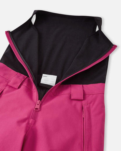 Close-up of the front zipper on the rosy berry Reima Alppi kids' snow bibs, revealing the cozy black fleece upper vest designed to provide extra core warmth and prevent drafts during winter play.