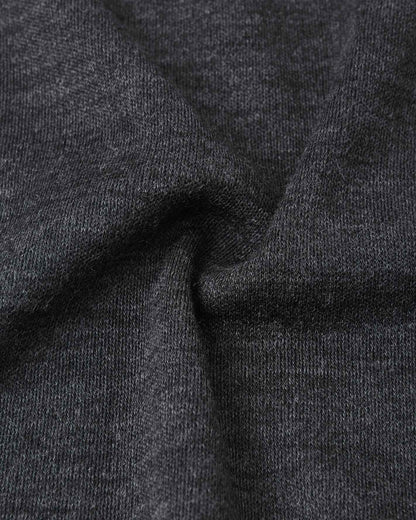 Macro close-up of the premium black melange wool knit fabric on the Reima Aurora kids' balaclava, highlighting the breathable, temperature-regulating base layer material.