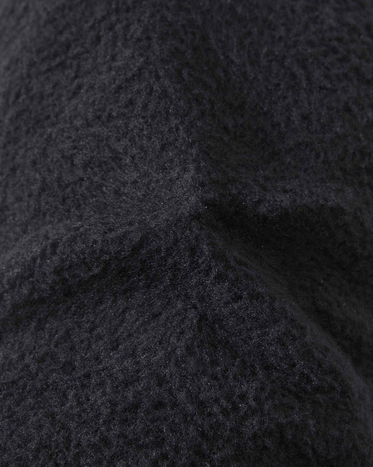 Macro close-up texture shot of the soft, brushed black fleece interior lining inside the Reima Hankas kids' ski gloves, demonstrating warm and breathable thermal insulation