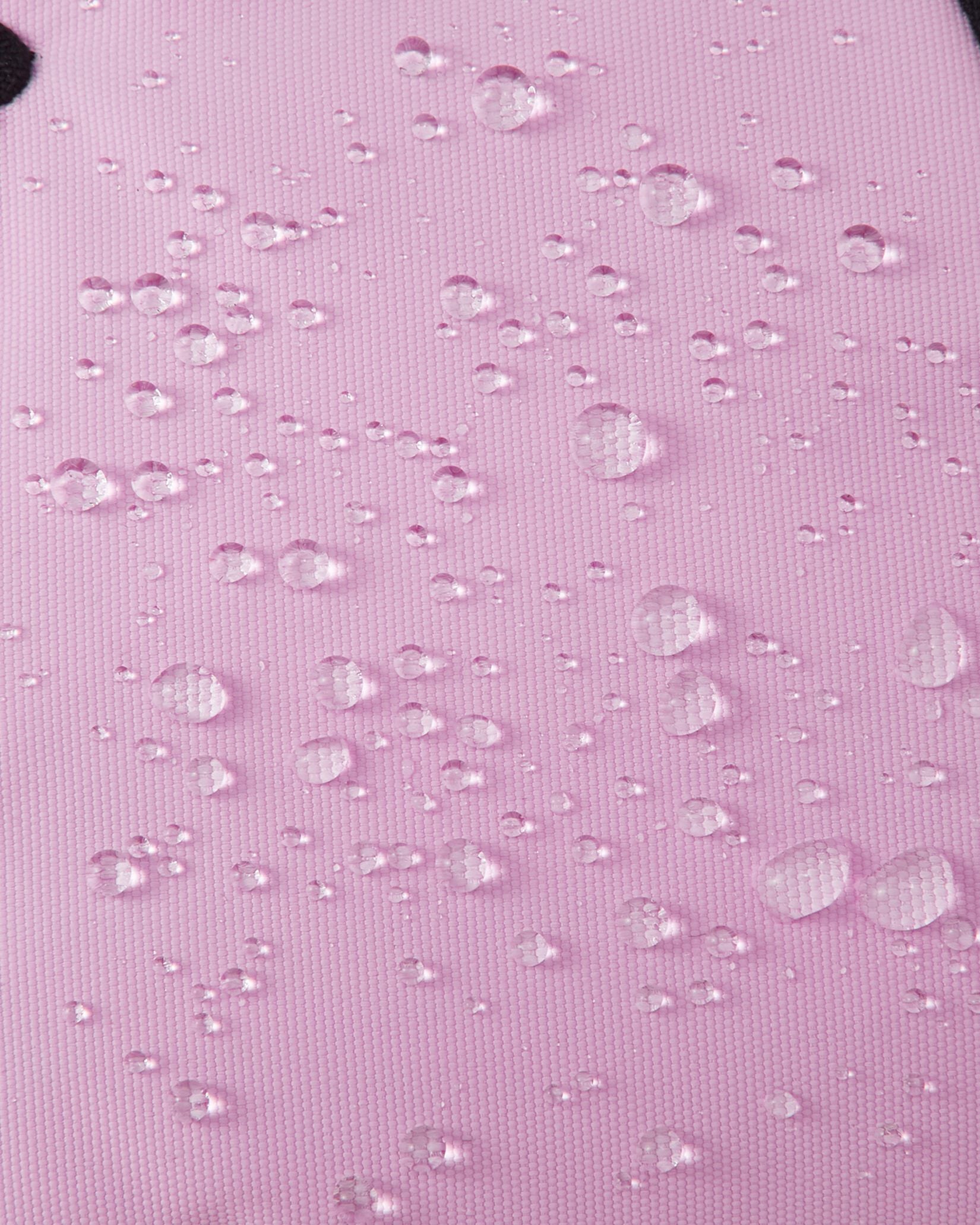 Macro texture shot of the light heather pink exterior fabric on Reima Hankas Reimatec kids ski gloves, with water droplets perfectly beading to showcase its highly waterproof finish.