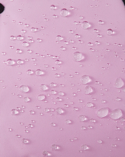 Macro texture shot of the light heather pink exterior fabric on Reima Hankas Reimatec kids ski gloves, with water droplets perfectly beading to showcase its highly waterproof finish.