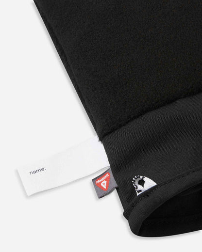 Detail of the inner cuff of the blooming lilac Reima Hanskas kids' ski gloves, showing the soft black fleece lining, a blank customizable name tag, and the premium PrimaLoft insulation tag for cold weather warmth.
