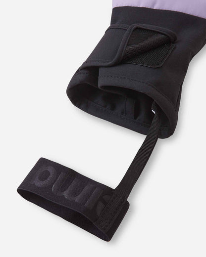 Close-up detail of the open cuff on the blooming lilac Reima Hanskas kids' ski gloves, highlighting the adjustable hook-and-loop closure strap and the elastic safety wrist leash designed to prevent dropped gloves on the mountain.