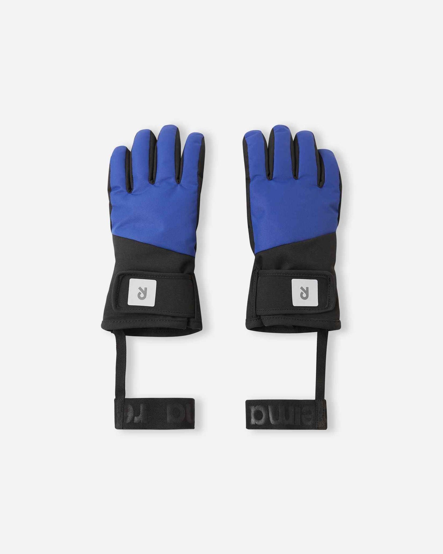 Flat lay view of the backs of the twilight blue Reima Hanskas kids' ski gloves. The image highlights the windproof and water-repellent BIONIC-FINISH®ECO treated fabric, an easy hook-and-loop adjustable wrist strap for a secure fit, and attached elastic safety wrist leashes.