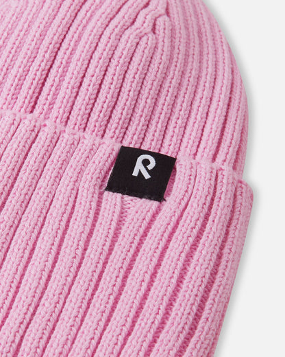 Close-up texture detail of the soft organic cotton ribbed knit on the light heather pink Reima Hattara kids' beanie, highlighting the contrast Reima logo patch.