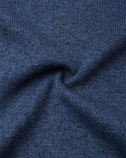 Macro close-up of the Reima Hopper kids' jeans blue knit fleece fabric, demonstrating the high-quality, sweater-like texture and thermal mid-layer performance.