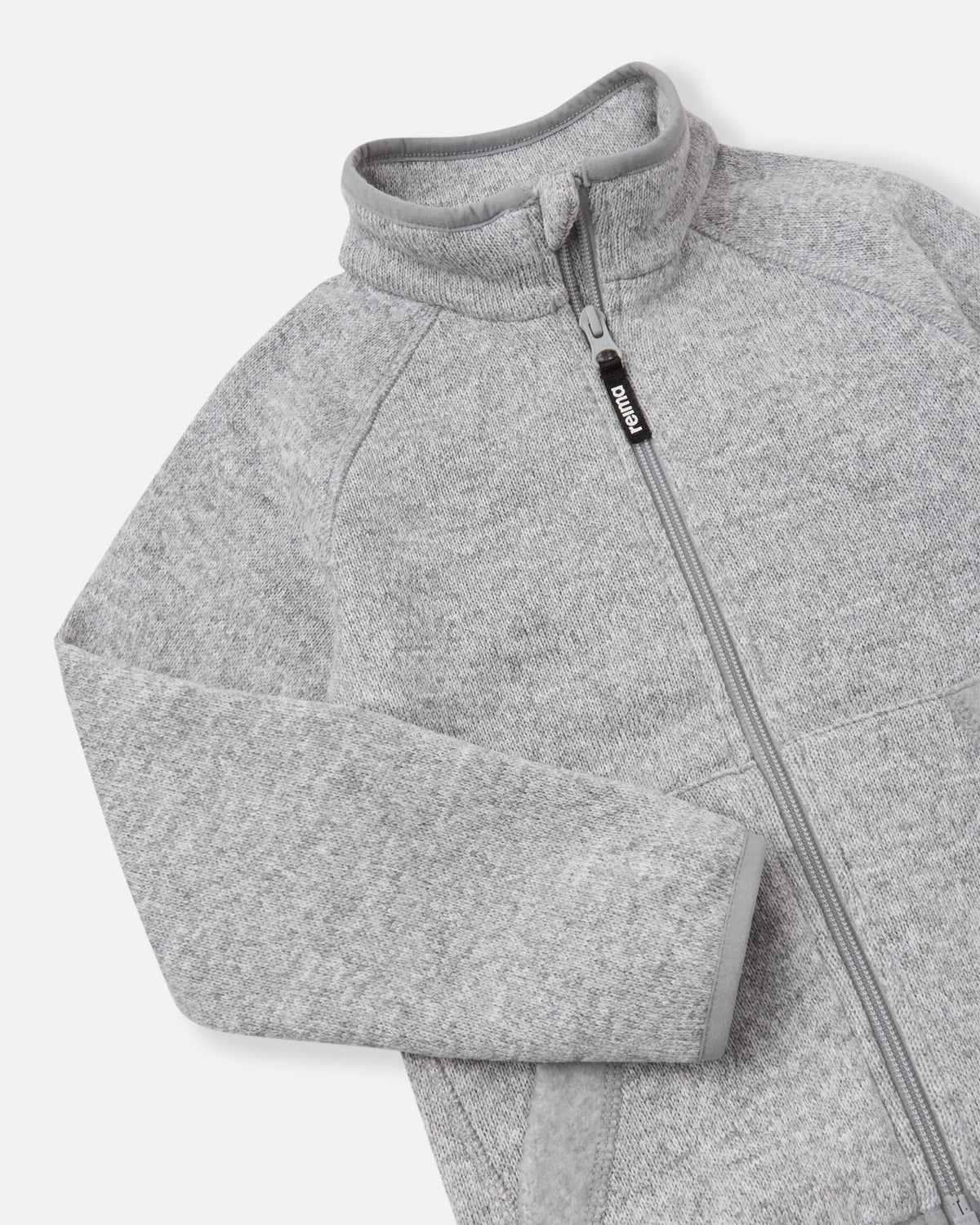 Close-up of the high collar and full-length zipper on the melange grey Reima Hopper kids' fleece jacket, highlighting the smooth zipper operation and anti-chafe chin guard design.
