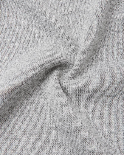 Macro close-up of the Reima Hopper kids' melange grey knit fleece fabric, demonstrating the high-quality, sweater-like texture and thermal mid-layer performance.