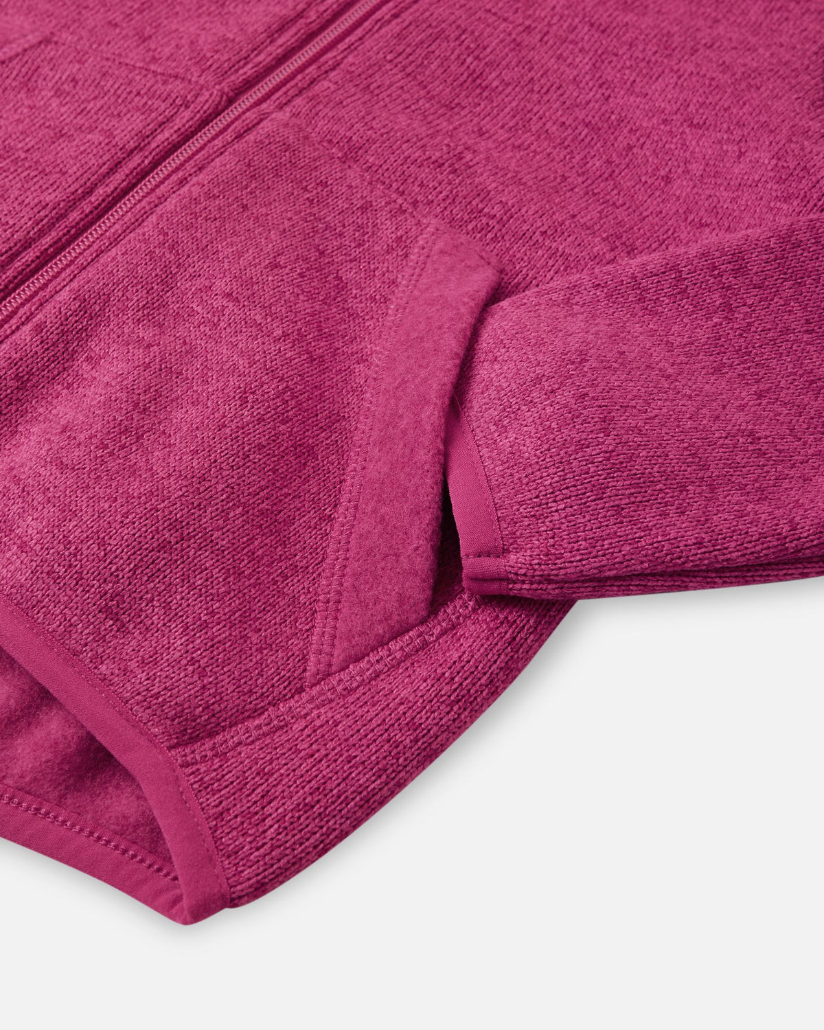 Detail view of the front handwarmer pocket on the Reima Hopper kids' rosy berry knit fleece jacket, featuring reinforced stitching for durability.