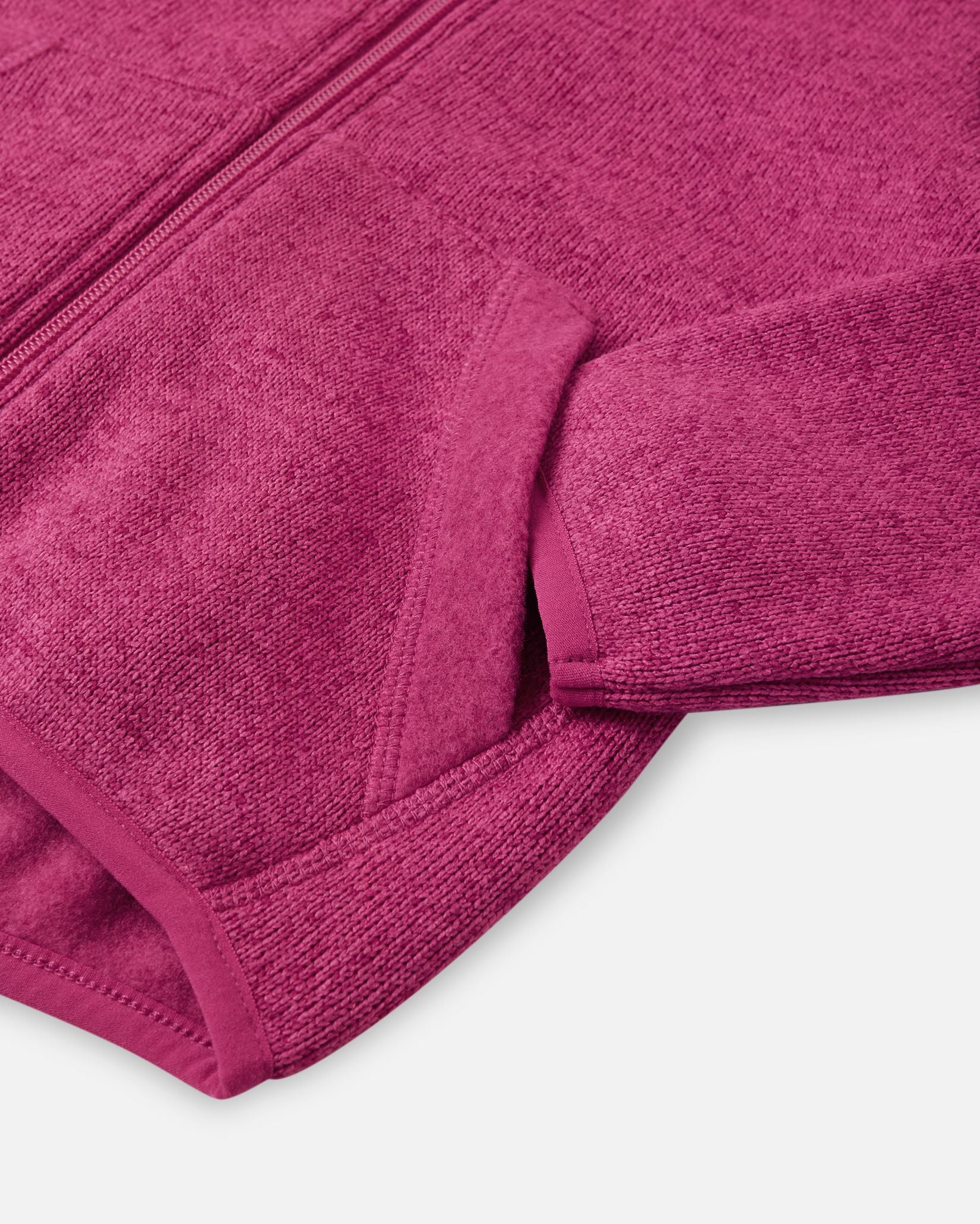 Detail view of the front handwarmer pocket on the Reima Hopper kids' rosy berry knit fleece jacket, featuring reinforced stitching for durability.