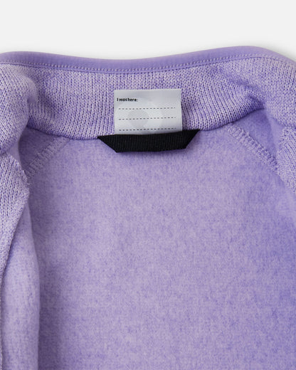 View of the inner neck label and writable name tag on the blooming lilac Reima Hopper kids' knit fleece jacket, showcasing the soft brushed fleece interior.