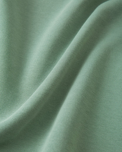Macro close-up of the ultra-soft, breathable organic cotton fabric used on the stone green Reima Huppis kids' hoodie, highlighting the high-quality, comfortable knit texture designed for everyday wear.