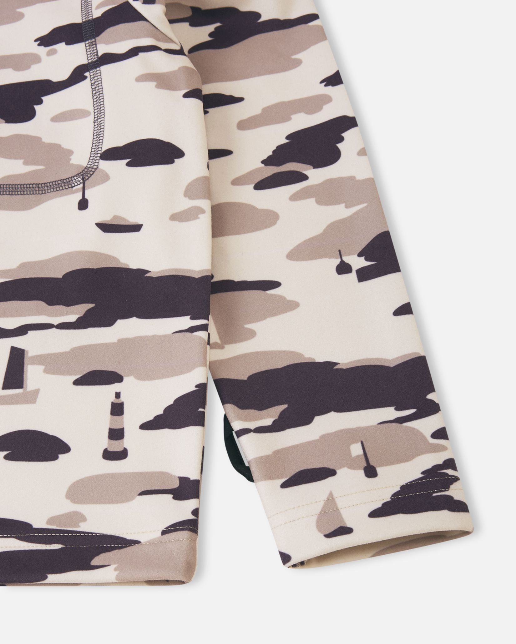 Detailed close-up of the lower body and sleeve cuff on the earthy beige Reima Iisisti kids' fleece jacket, highlighting the clean hem finish and the intricate nautical sailboat and lighthouse camo print.