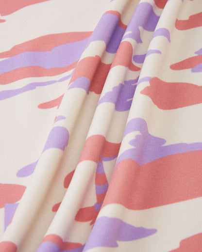 Macro close-up of the soft, smooth-faced fleece fabric used on the rose blush Reima Iisisti kids' jacket, showing the precise details of the pink, purple, and cream sailboat camo print.