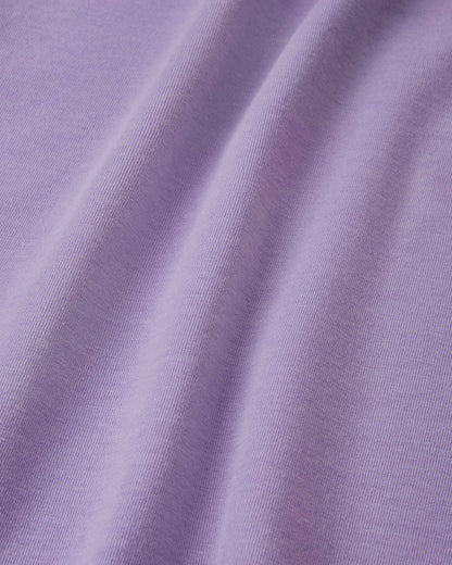 Close-up detail of the smooth, blooming lilac UPF 50+ fabric on the Reima Ikioma kids' summer t-shirt, showing the breathable knit structure that provides lasting comfort and UV protection.