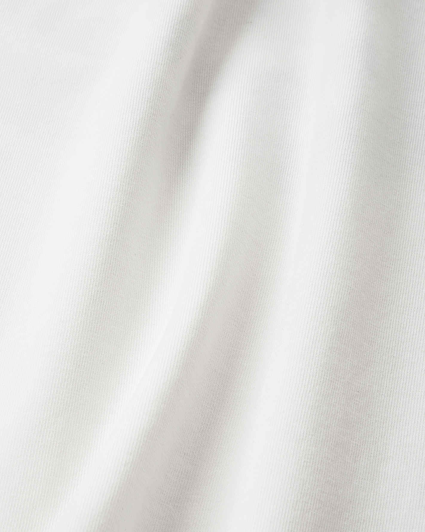 Detailed close-up of the crisp, off-white UPF 50+ fabric on the Reima Ikioma kids' summer t-shirt, demonstrating the high-quality, stretch-knit material designed for comfortable sun protection.