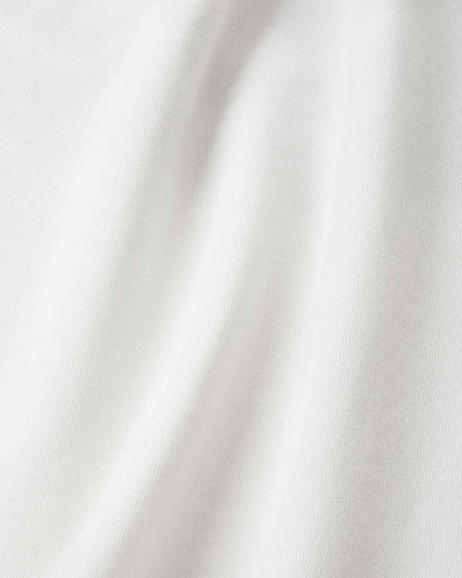 Detailed close-up of the crisp, off-white UPF 50+ fabric on the Reima Ikioma kids' summer t-shirt, demonstrating the high-quality, stretch-knit material designed for comfortable sun protection.