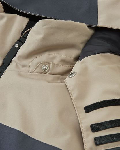 Close-up detail of the smooth protective collar and the safe, easy-to-use snap button attachments for the hood on the earthy beige Reima Jatuni kids' ski jacket.