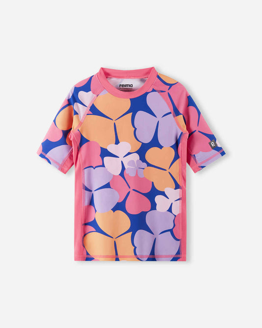 Front view of the Reima Joonia girls' UPF 50+ sunproof rash guard, showcasing a bold soft coral, pink, and purple oversized floral print, crafted from highly protective UV-blocking swimwear material.