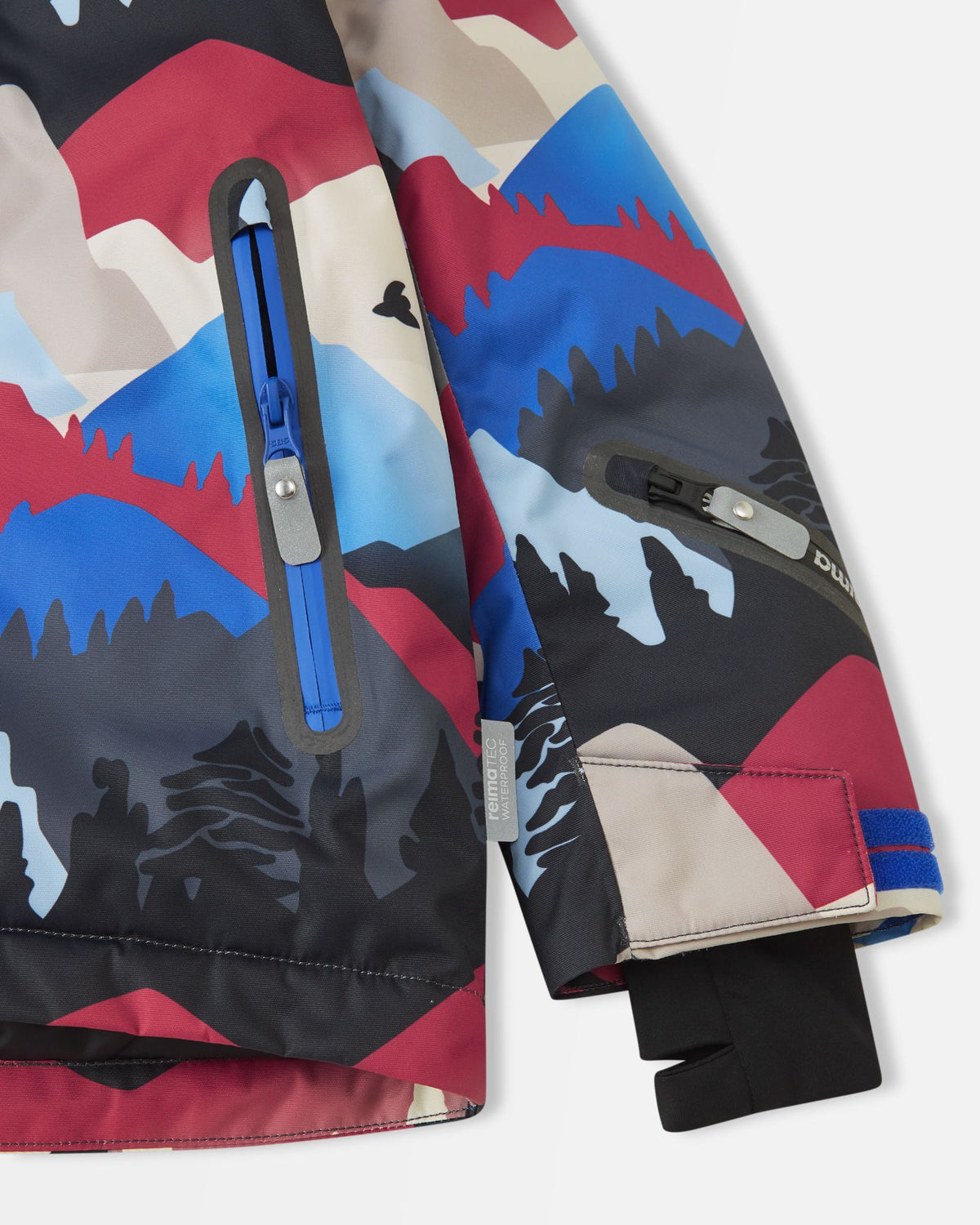 Close-up of the sleeve on the Reima Kairala kids' ski jacket, showing the adjustable Velcro outer cuff, black Lycra inner cuff with thumbhole, blue zippered ski pass pocket, and the Reimatec waterproof authenticity tag.
