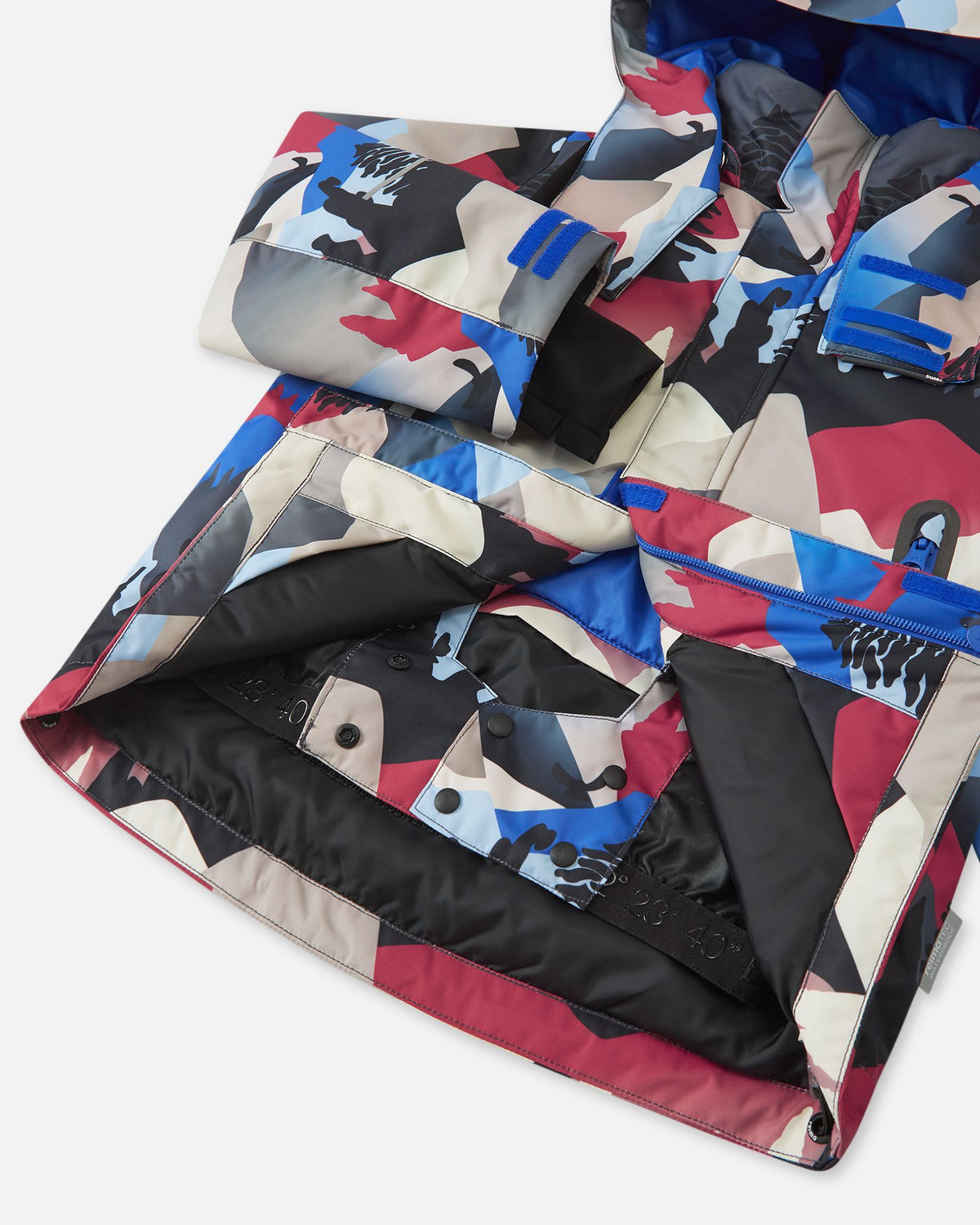 Interior view of the Reima Kairala kids' ski jacket, revealing the smooth black lining and the built-in snap-button snow lock powder skirt designed to keep snow out during winter sports.