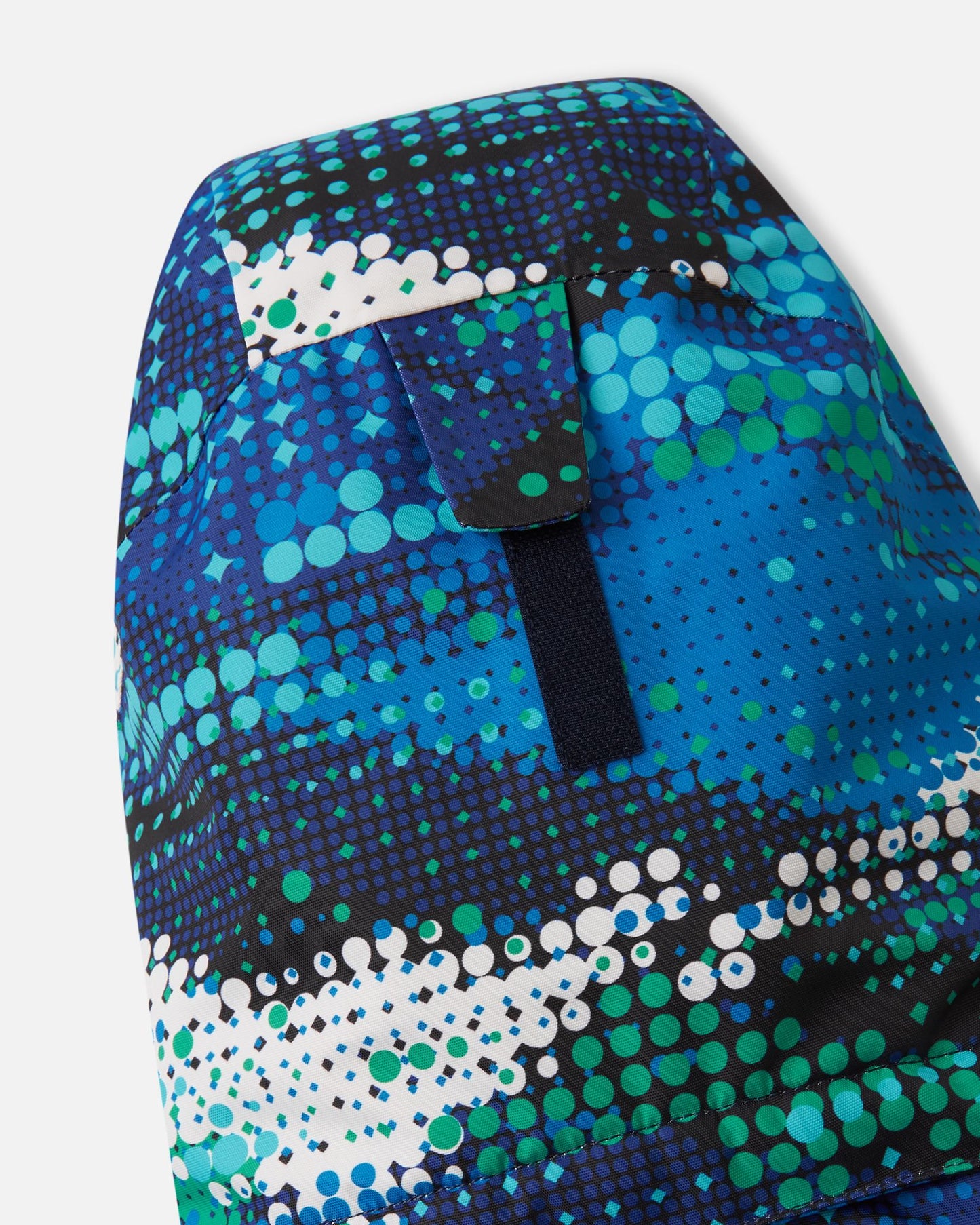 Close-up view of the adjustable velcro strap on the back of the helmet-compatible hood of the twilight blue Reima Kairala kids' waterproof winter ski jacket.