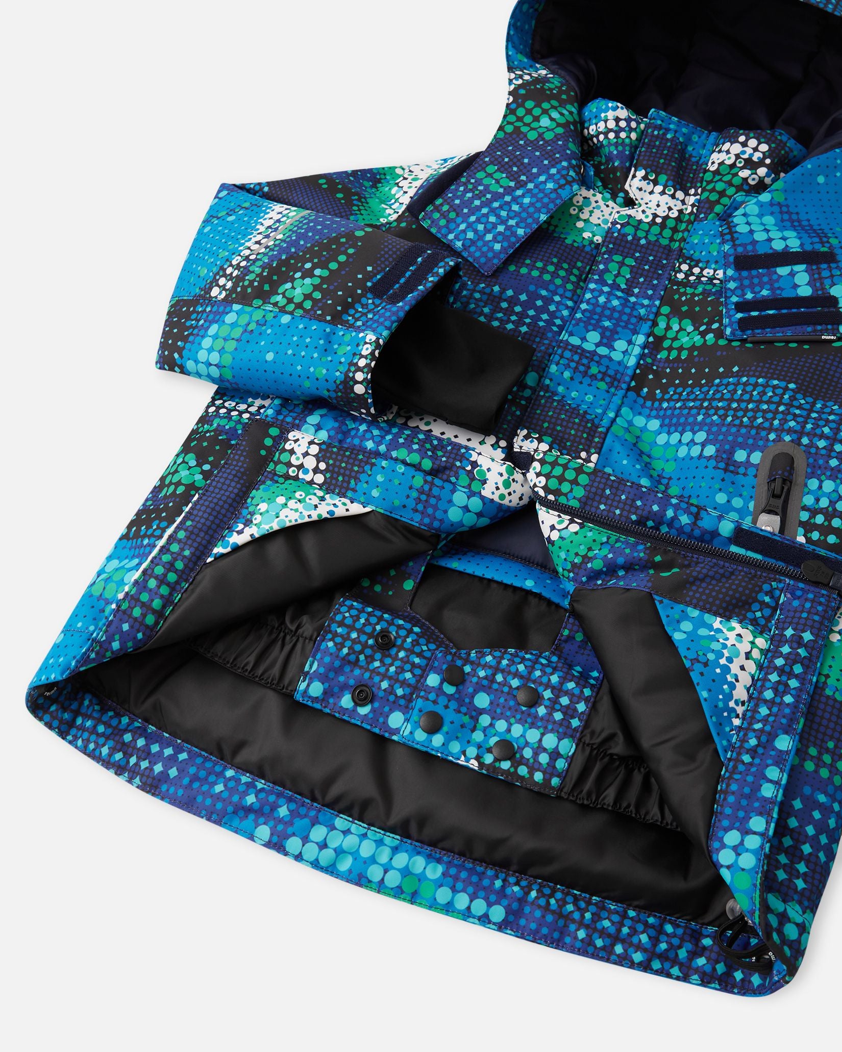 Open front view of the twilight blue Reima Kairala kids' ski jacket, highlighting the internal snap-button powder skirt designed to keep out snow and cold drafts during winter sports.