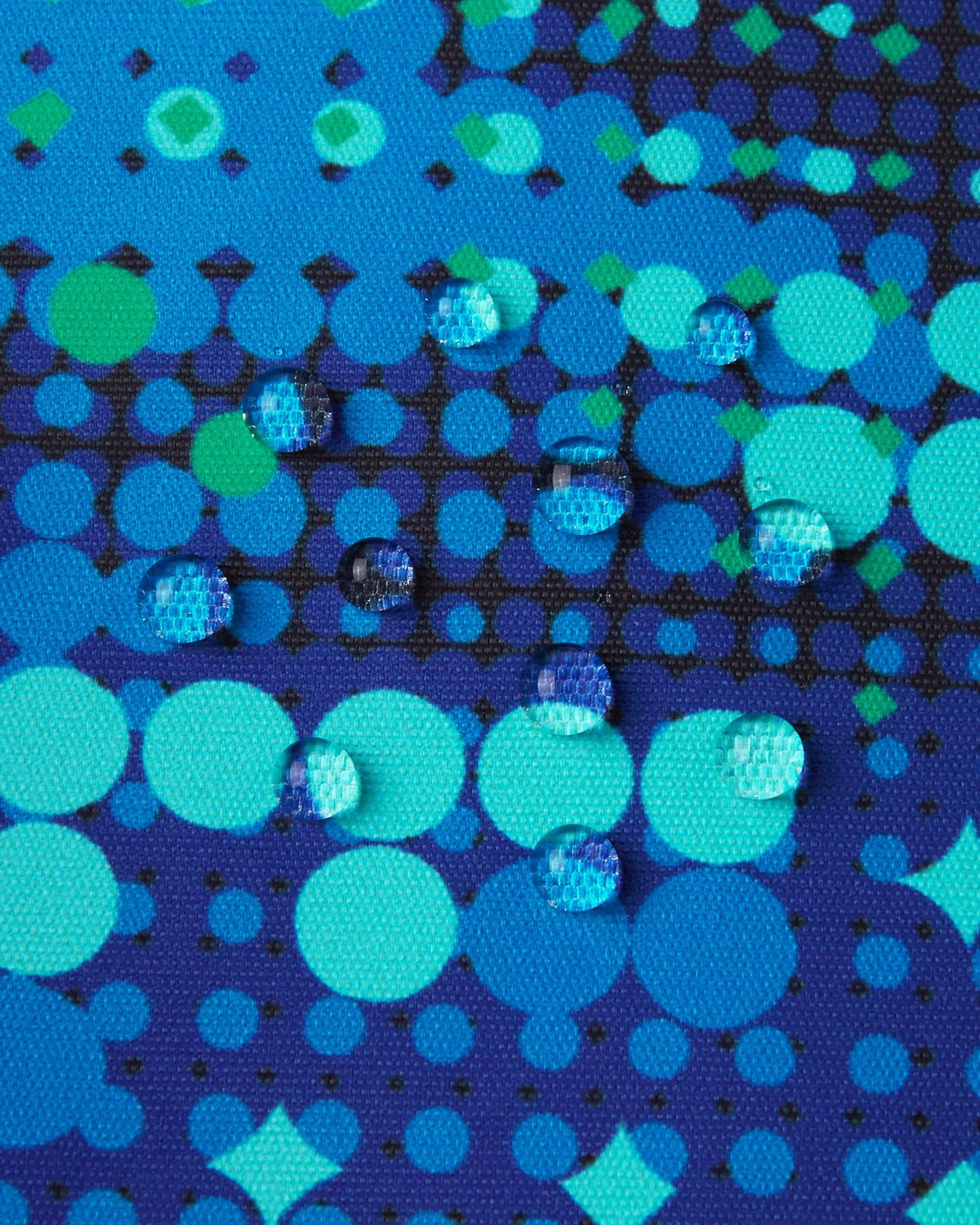 Macro close-up of water droplets perfectly beading on the surface of the twilight blue Reima Kairala kids' ski jacket, demonstrating the high-performance waterproof and breathable Reimatec outer fabric.