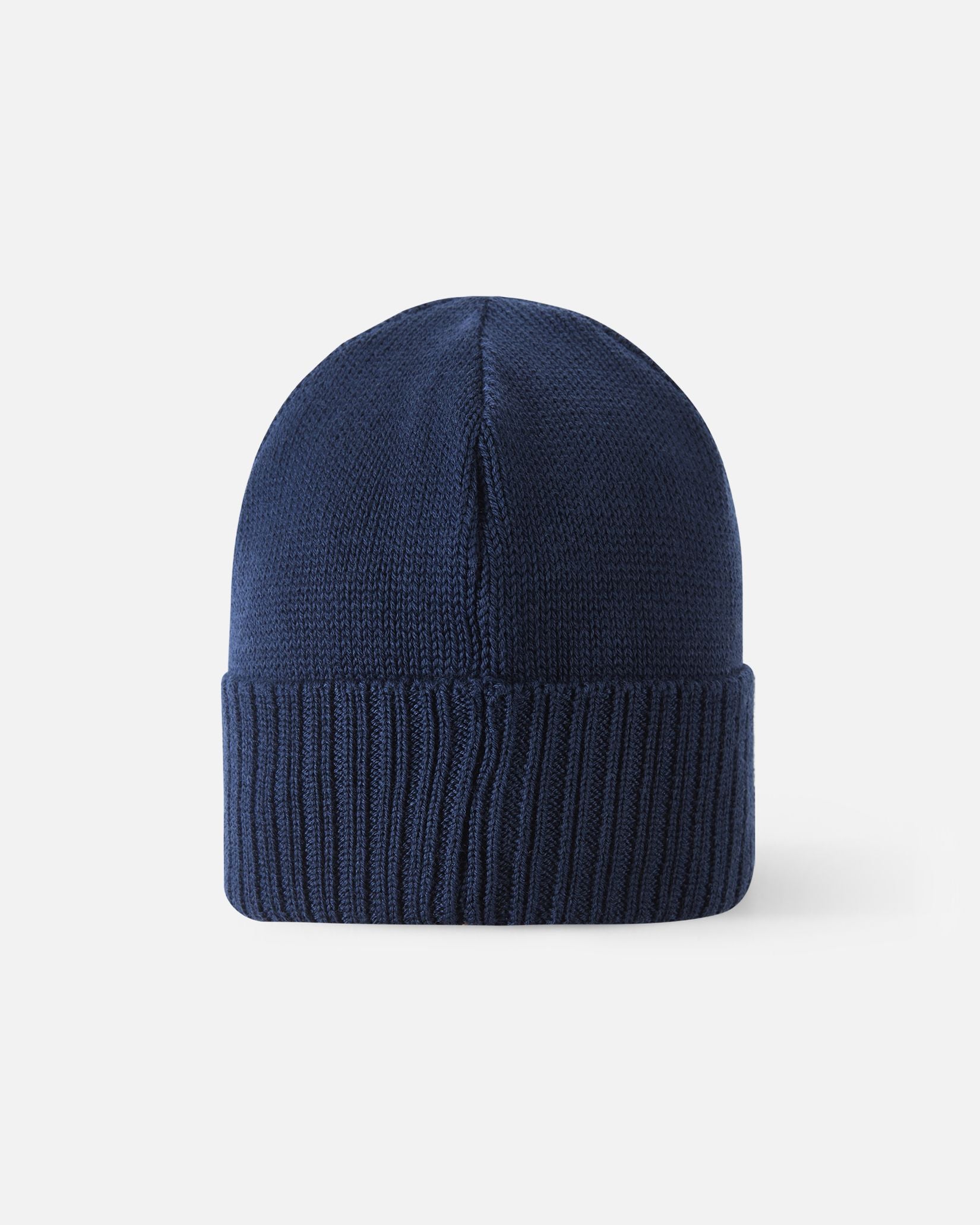 Angled side view of the navy blue Reima Kalotti kids' merino wool beanie hat, highlighting the small black Reima logo tag on the ribbed brim.