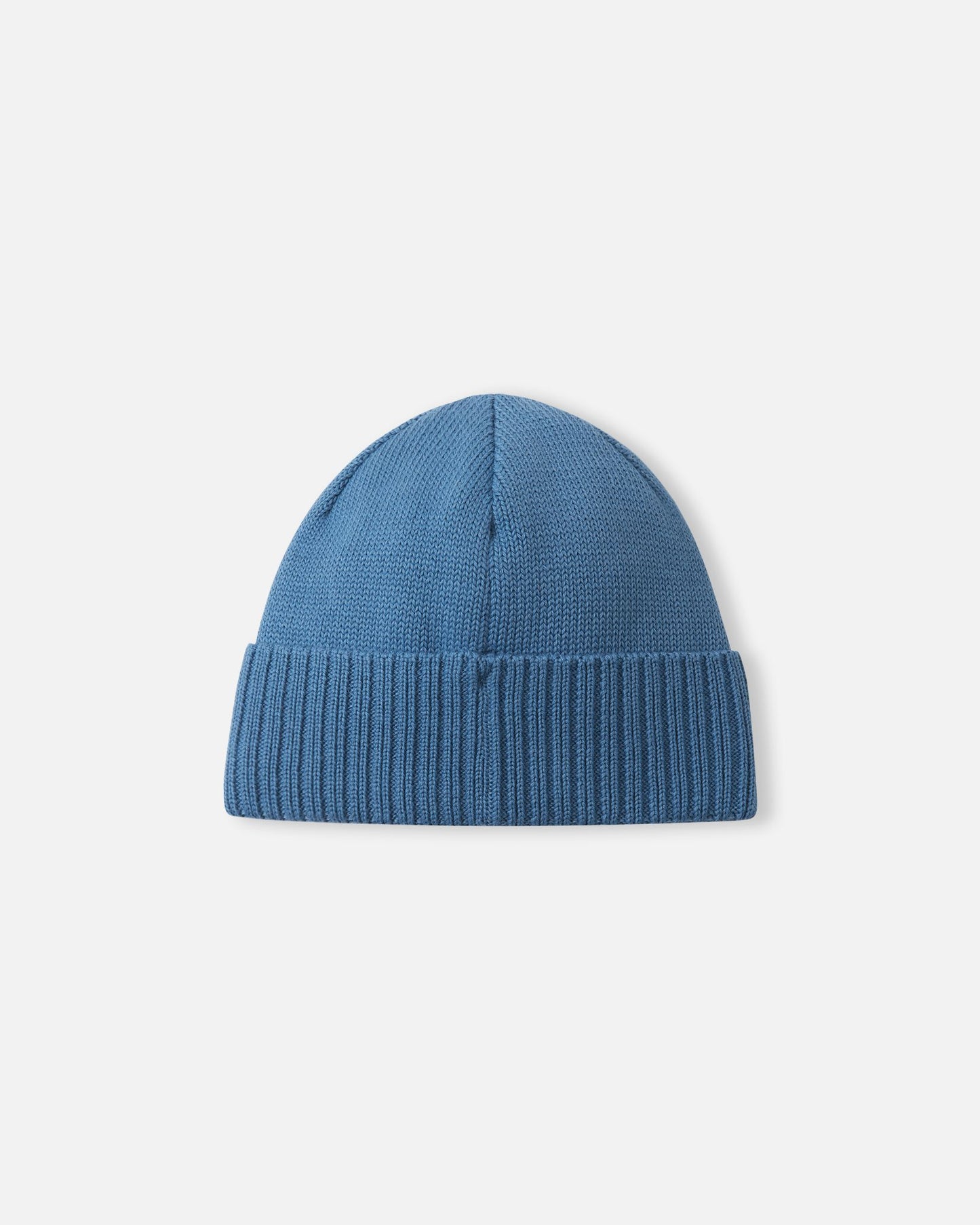 Angled side view of the ocean blue Reima Kalotti kids' merino wool beanie hat, highlighting the small black Reima logo tag on the ribbed brim.
