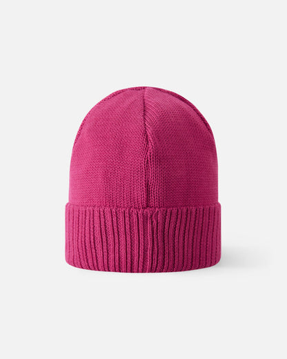 Angled side view of the rosy berry pink Reima Kalotti kids' merino wool beanie hat, highlighting the small black Reima logo tag on the ribbed brim.