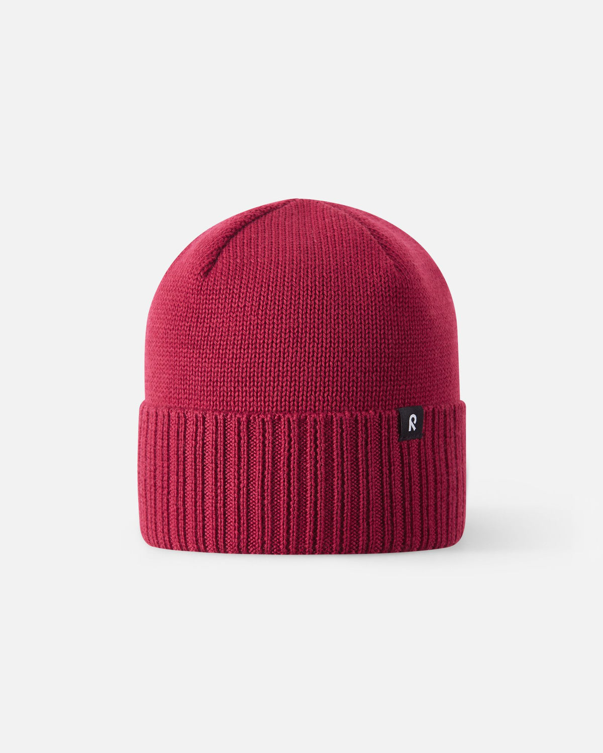 Straight-on view of the cranberry red Reima Kalotti kids merino wool beanie, showcasing its traditional Scandinavian winter design, unlined breathable upper crown, and thick heat-retaining ribbed cuff.