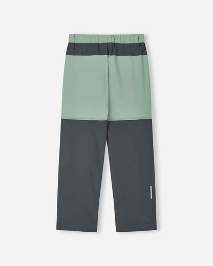 Back view of the stone green Reima Kaveris kids' hiking pants, showcasing the dark grey reinforced seat, reflective safety detail on the lower leg, and durable stretch fabric for outdoor adventures.