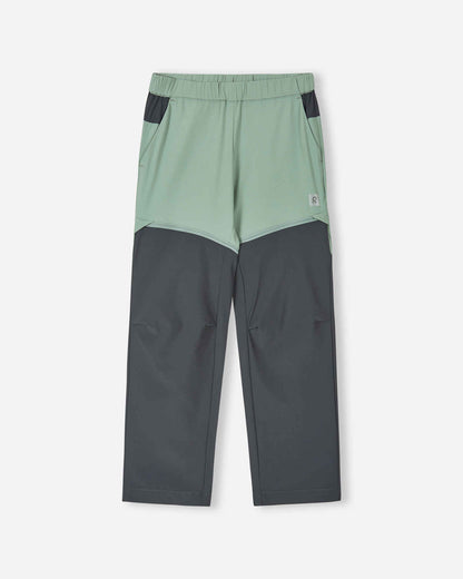 Front view of the Reima Kaveris kids' convertible hiking pants in stone green, featuring dark grey reinforced knee panels, an elastic waistband, and hidden zippers that convert the pants into shorts