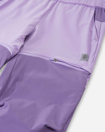 Detailed close-up of the concealed zipper on the Reima Kaveris kids' blooming lilac convertible pants, showing the secure and smooth attachment of the darker purple lower leg panels.