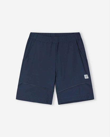 Front view of the Reima Kaveris kids' hiking pants converted into navy blue shorts, highlighting the versatile zip-off design, relaxed fit, and practical side pockets for warm weather hiking.