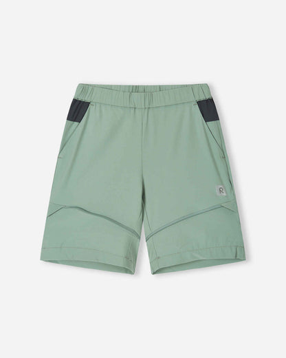 Front view of the Reima Kaveris kids' hiking pants converted into stone green shorts, demonstrating the versatile zip-off design, comfortable fit, and practical dark grey pocket details.