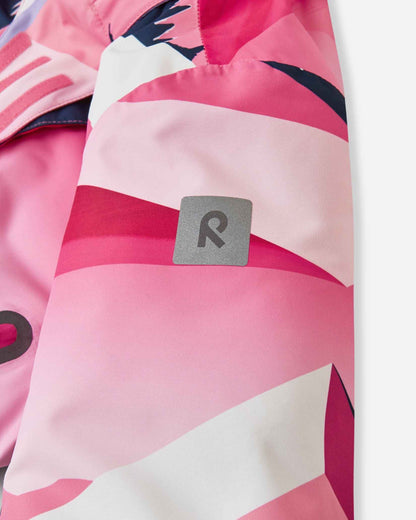 Detail view of the left sleeve on the soft coral mountain print Reima Kiiruna children's ski jacket, highlighting the square reflective Reima logo patch designed for high visibility in low-light winter conditions.