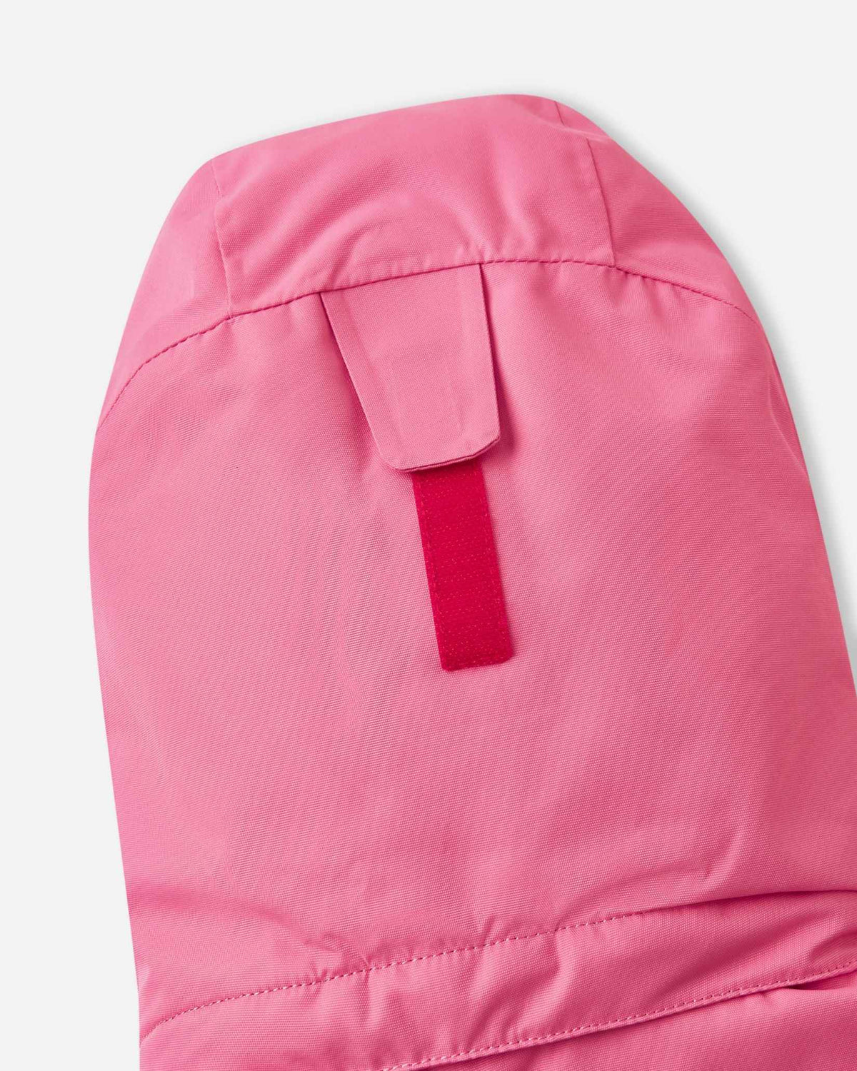 Close-up of the hook-and-loop velcro adjustment strap on the back of the soft coral Reima Kiiruna children's ski jacket hood, engineered to provide a customizable and secure fit over winter beanies.